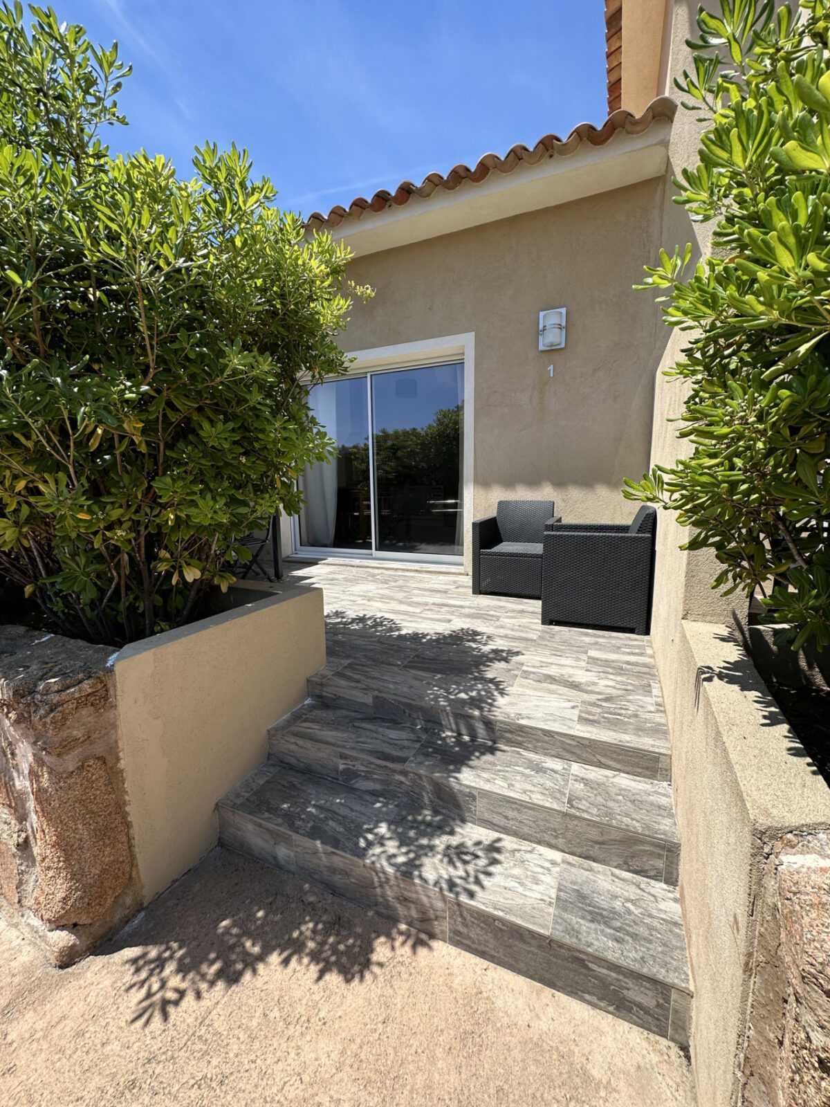Terrasse spacieuse avec salon de jardin et vue sur la piscine en Corse du Sud